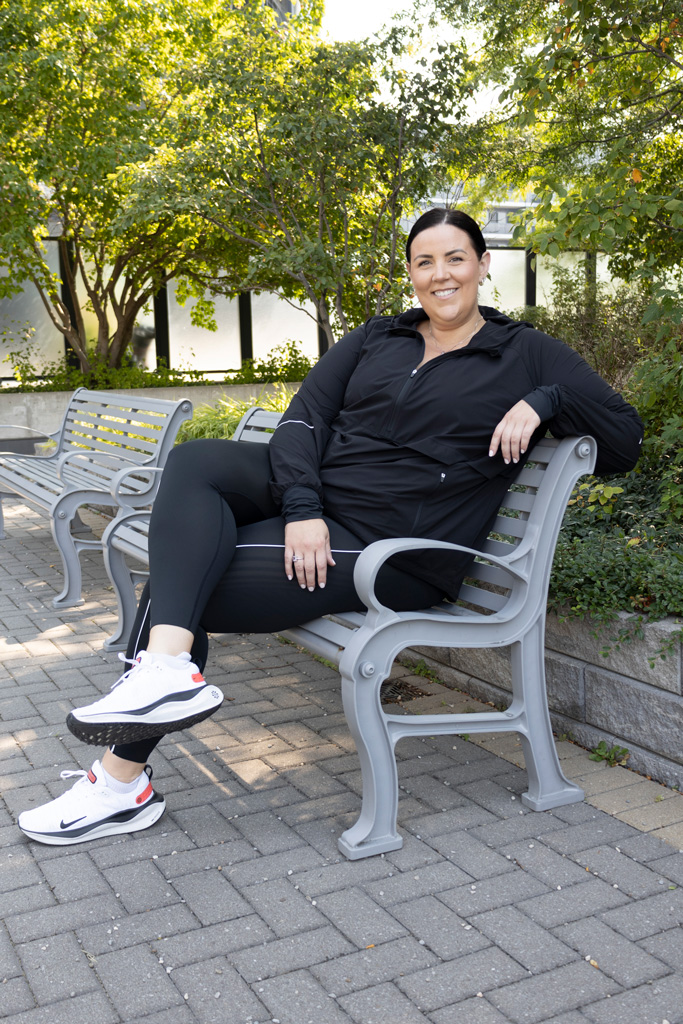 Coach is sitting outddors in a bench wearing a black tracksuit.